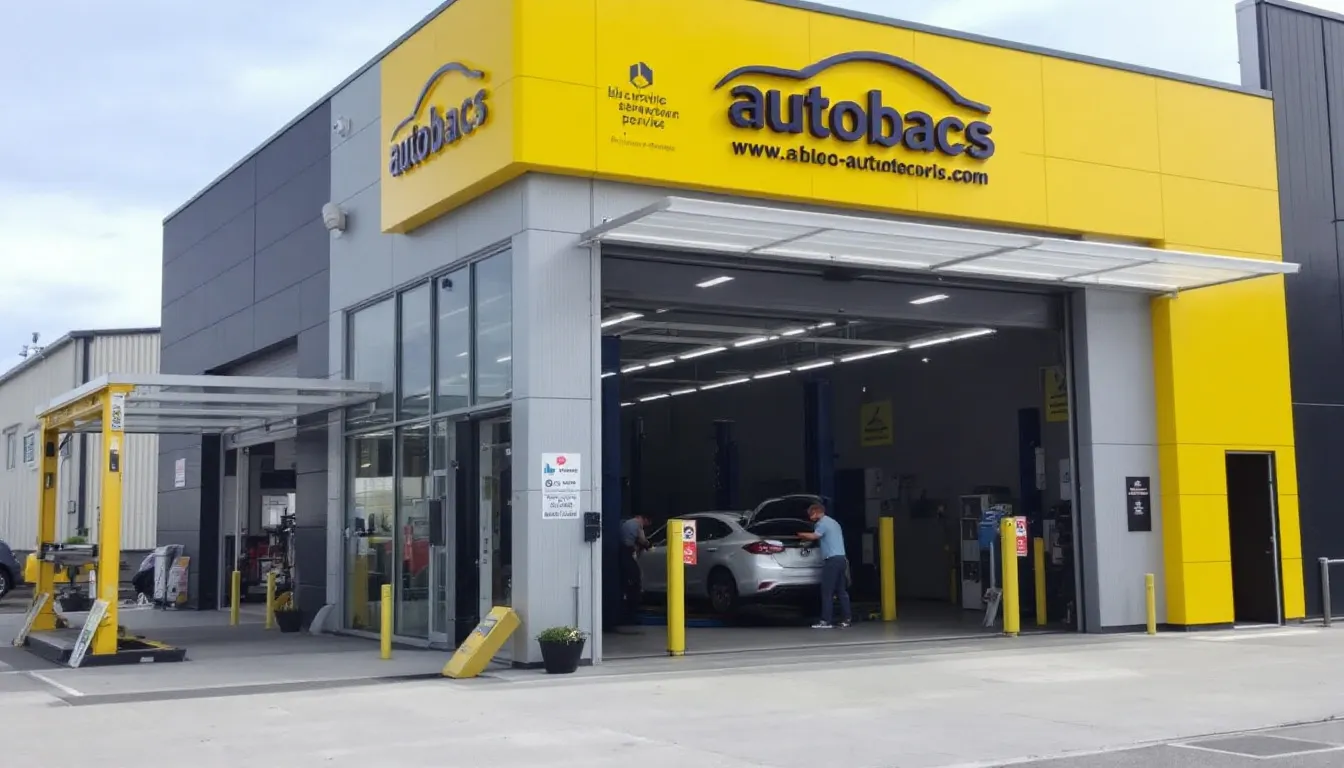 オートバックスの店舗外観とピットサービスエリアが映し出されており、スパークプラグ交換やエンジンオイルのメンテナンスが行える場所としての雰囲気が伝わります。整備士が作業を行う姿が見られ、クルマのメンテナンスに気軽に訪れることができる印象を与えています。